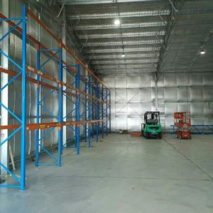 view inside warehouse shed with racking and forklifts